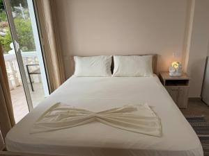 uma cama branca com um laço em Vila Horizont em Baks-Rrjoll