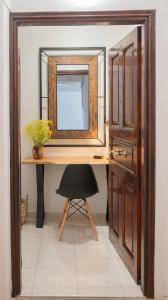 Habitación con escritorio con espejo y silla. en Cloe Corfu Airport Apartment en Anemómylos