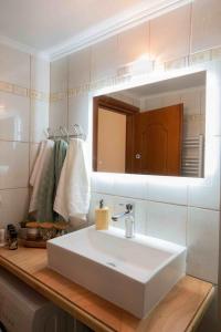 y baño con lavabo blanco y espejo. en Cloe Corfu Airport Apartment en Anemómylos