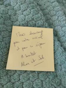 een stuk papier met een handschrift op een deken bij Écrin de nature sous les pins in Aurons