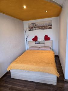 a bedroom with a bed with two hearts on the wall at R&J Apartment I in Panevėžys