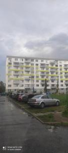 a parking lot with cars parked in front of a large building at Apartmán Sofia in Levice