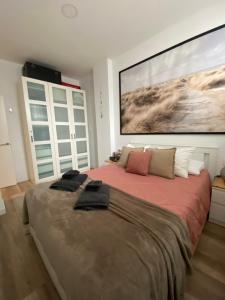 a bedroom with a large bed with a large painting on the wall at Apartamento Donosti Aldea in Lasarte