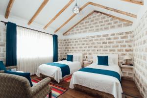 duas camas num quarto com uma parede de tijolos em Hotel de Sal Luna Salada em Colchani