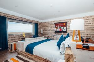 a bedroom with a large bed and a brick wall at Hotel de Sal Luna Salada in Colchani