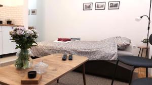 een slaapkamer met een bed en een tafel met een vaas met bloemen bij Studi-apartman Kestenov stan in Vršac