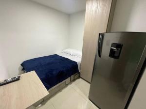 Cette petite chambre comprend un lit et un réfrigérateur. dans l'établissement Apartaloft en el centro 205, à Pereira
