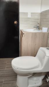 a bathroom with a white toilet and a sink at El Hogar de Ami in Cali