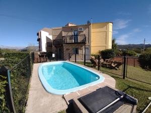 a swimming pool in front of a house at Cabañas La Soleada in Potrero de los Funes
