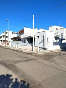 une rue vide devant un bâtiment blanc dans l'établissement L'Angolo di Mimma, à Porto Cesareo