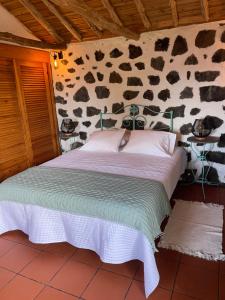 Cama en habitación con pared de vaca en Casa do Carregadouro - Seaside Retreat, en São Roque do Pico