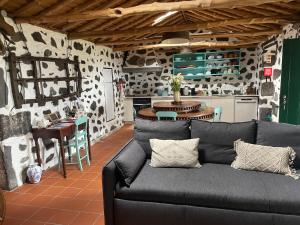 Una sala de estar con un sofá y una cocina. en Casa do Carregadouro - Seaside Retreat, en São Roque do Pico
