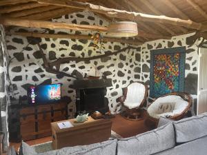 un soggiorno con divano e TV di Casa do Carregadouro a São Roque do Pico