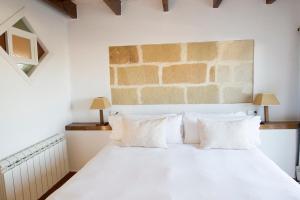 sypialnia z białym łóżkiem i białymi poduszkami w obiekcie Llucmaçanes Gran Agroturismo w mieście Mahón