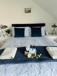 a bed with a blue comforter with a basket of drinks and bottles at Coastal Haven 5 Bed Gem in Portrush Center in Portrush