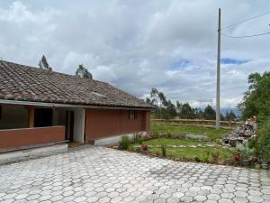 a house with a stone driveway in front of it at Casita Hierbabuena in Ibarra