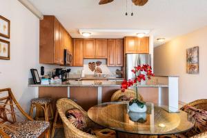 a kitchen with a glass table with chairs and a counter at Live da HI life--great beach and great views! in Wailea
