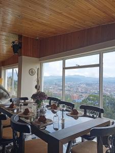 einen Esstisch mit Stadtblick in der Unterkunft Di Carbone Hotel Gastrobar in Facatativá