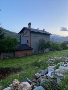 una casa en una colina con rocas delante de ella en The Hill House en Prizren