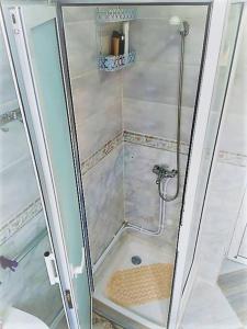 une douche avec une porte en verre à côté des toilettes dans l'établissement Appartement cosy tout équipé centre-ville, Tlemcen, à Tlemcen