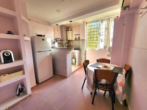 a small kitchen with a table and a refrigerator at Appartement cosy tout équipé centre-ville, Tlemcen in Tlemcen