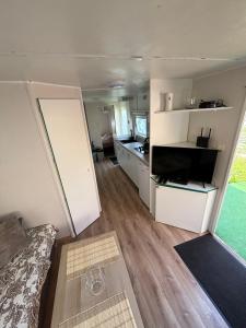 a room with a kitchen and a living room at Domek holenderski Lilla in Łeba +5 photos