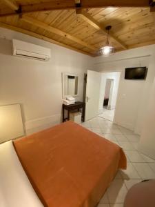 - une chambre avec un lit et un bureau dans l'établissement Paradosi Rooms, à Igoumenítsa