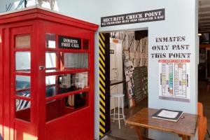 une cabine téléphonique rouge à côté d'une table en bois dans l'établissement Jailhouse Accommodation, à Christchurch