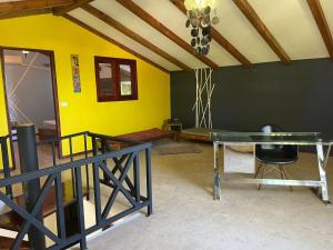ein Esszimmer mit einem Glastisch und einer gelben Wand in der Unterkunft Bel appartement pour 6 personnes avec vue mer in Las Terrenas