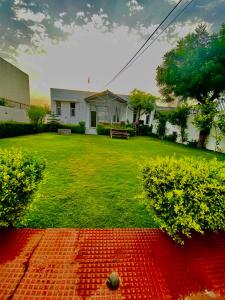 a green yard with a bench in a yard at Solanki farms & Pool Villa garden fully private in Jaipur
