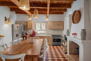 cocina grande con mesa de madera y sillas en Villa Aromata, en Trudda