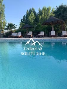 a swimming pool at a villa with blue water at Complejo Solitudine in Cacheuta