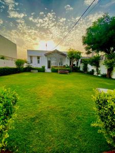 a yard with a bench and a building at Solanki farms & Pool Villa garden fully private in Jaipur