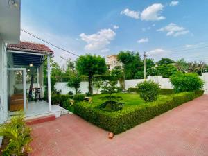 a garden in a house with a green hedge at Solanki farms & Pool Villa garden fully private in Jaipur