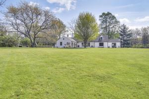 una gran casa blanca con un gran campo de césped en Knoxville Area Getaway on 22 Acres with Pond Access!, en Galesburg
