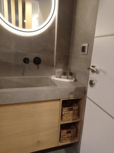 a bathroom with a sink and a mirror at La Casa Del Rio in Kymi