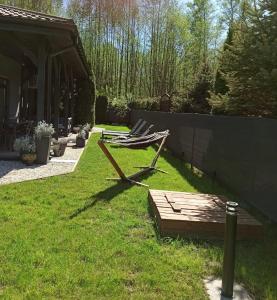 ławka siedząca na trawie na podwórku w obiekcie Dom na Polanie w Boszkowie