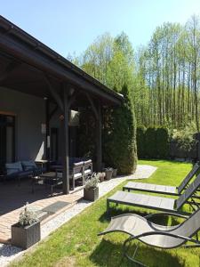 a patio with two benches and a picnic table at Dom na Polanie in Boszkowo