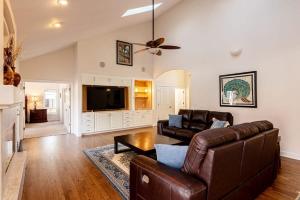 a living room with leather furniture and a flat screen tv at Luxurious 4BR Retreat - Pool Table & Chic Amenities in Boulder