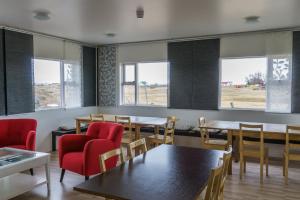 a dining room with tables and chairs and windows at Vogar Travel Service in Myvatn