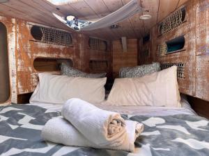 1 dormitorio en una cabaña con cama y almohadas en Barco Puerto de Santa Maria en El Puerto de Santa María