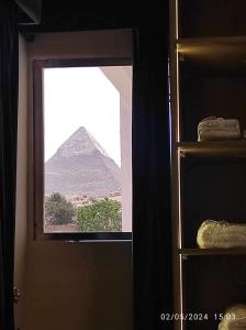 una finestra con vista sulle piramidi in una stanza di Alma Pyramids View a Il Cairo
