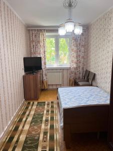 una camera con letto e TV a schermo piatto di Апартаменты на Ахметова 10 a Turksib