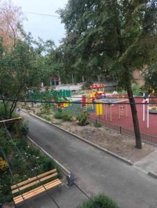 una panchina accanto a un fiume con parco giochi di Апартаменты на Ахметова 10 a Turksib