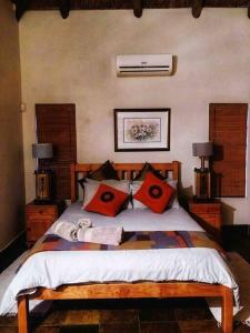 a bedroom with a bed with red pillows on it at The Yellow House in Brits +28 photos