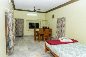 a bedroom with a bed and a table and a dining room at Live Inn RMS in Tiruchchirāppalli