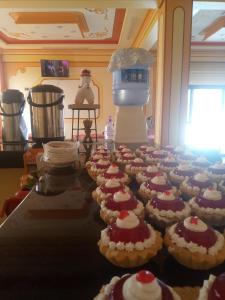 a table full of cupcakes with red and white icing at salt beds of salt hostal in Uyuni