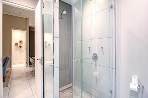 a glass shower with a glass door in a bathroom at 2bedroom apartments at Menlyn Maine on 16th in Pretoria