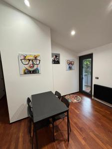 a dining room with a table and some pictures on the wall at B&B Tre scimmiette in Tarcento