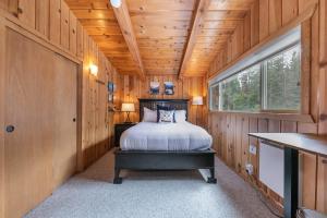 Carnelian Bayにある3BD Retreat - 5 Min to Beach Trails & Townの木製の部屋にベッド1台が備わるベッドルーム1室があります。